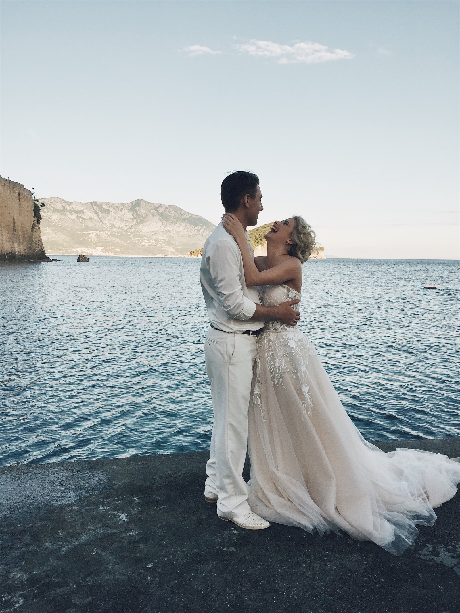 Newlyweds embracing on the coast