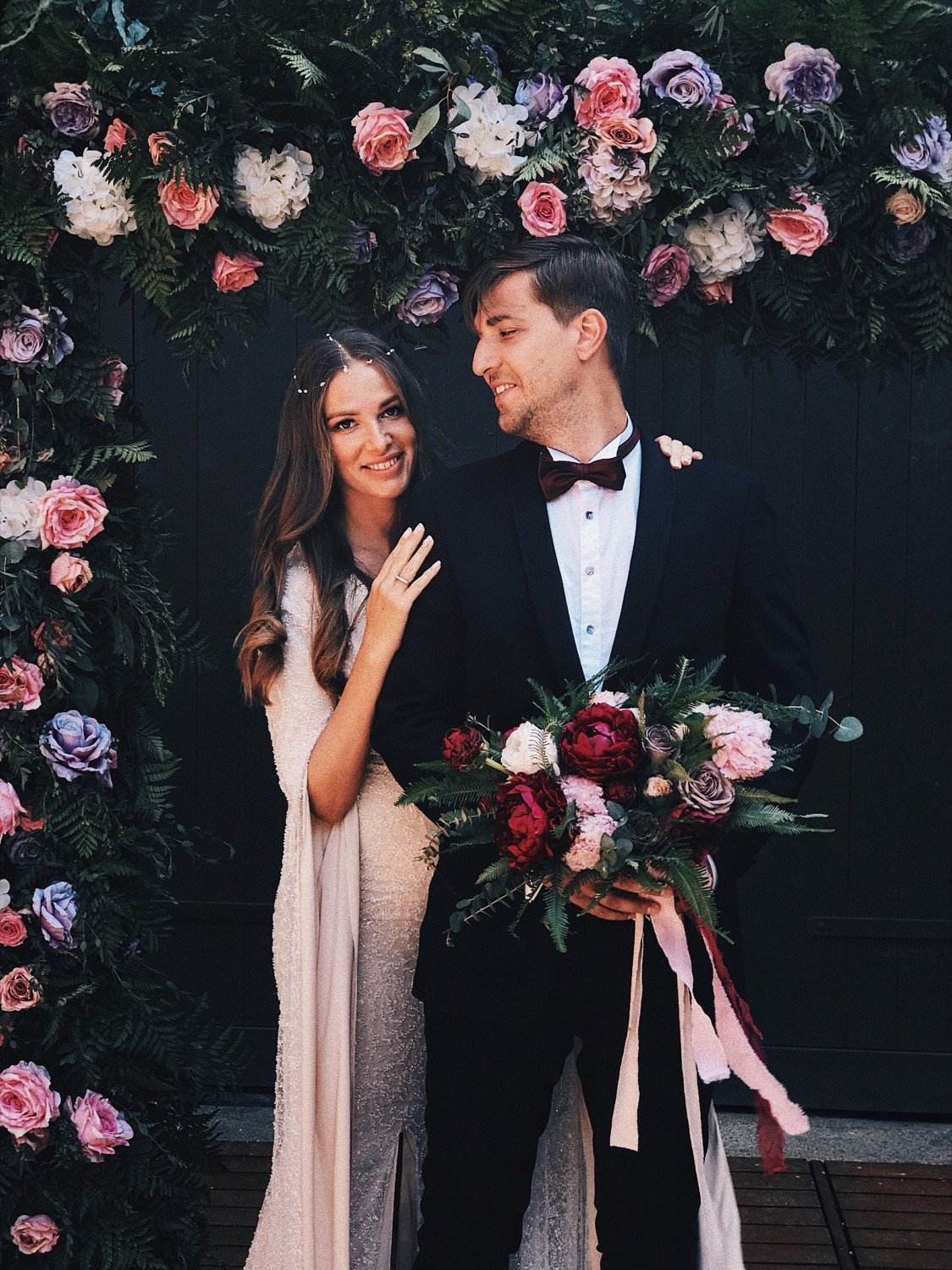 A couple celebrating beneath flowers at their destination wedding